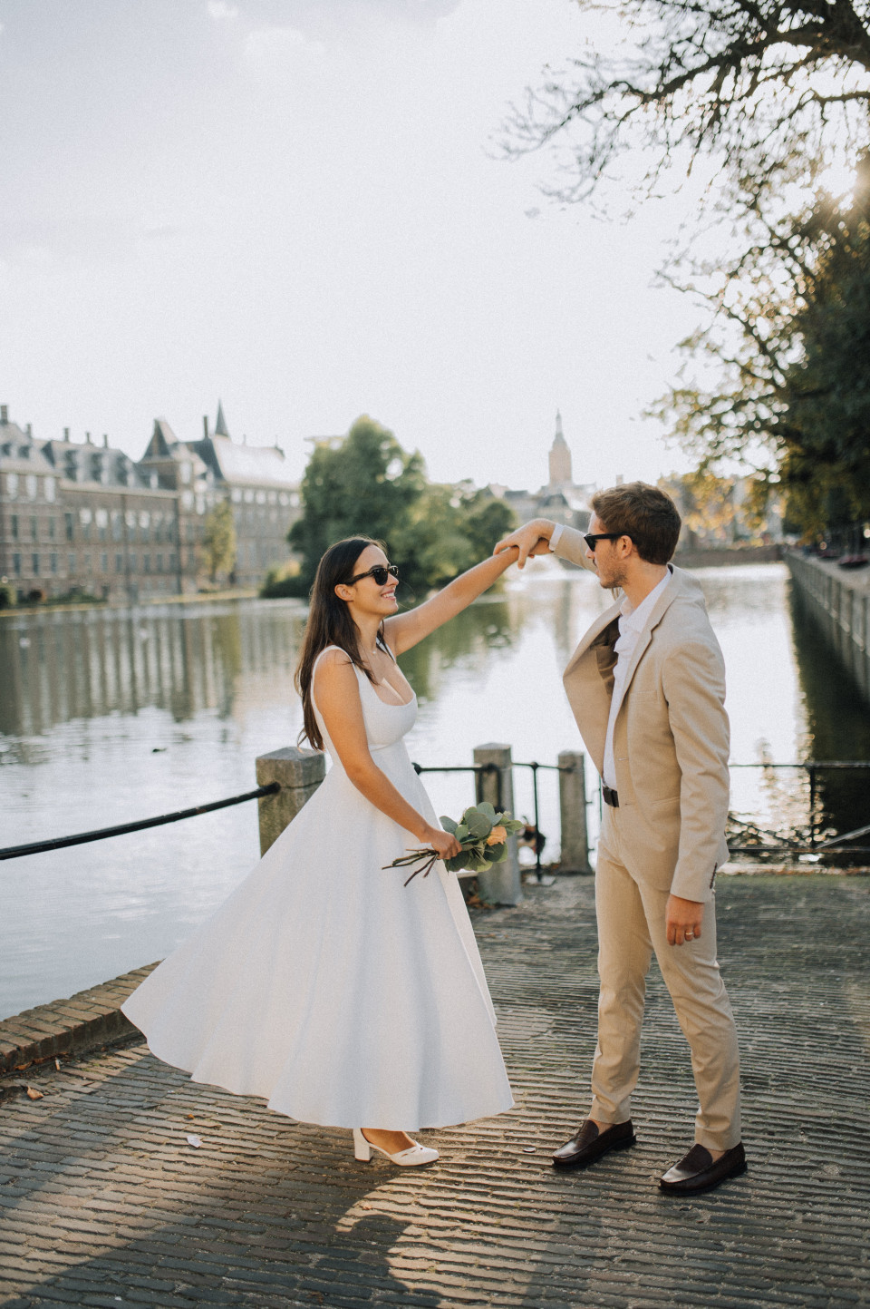 een bruid en bruidegom dansen bij het water in amsterdam