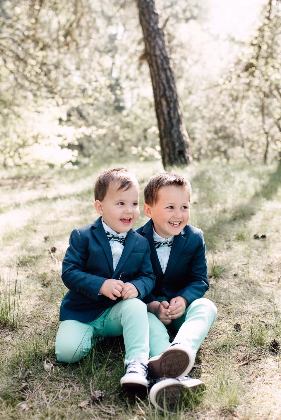 twee jongens in blauwe pakken die op de grond zitten