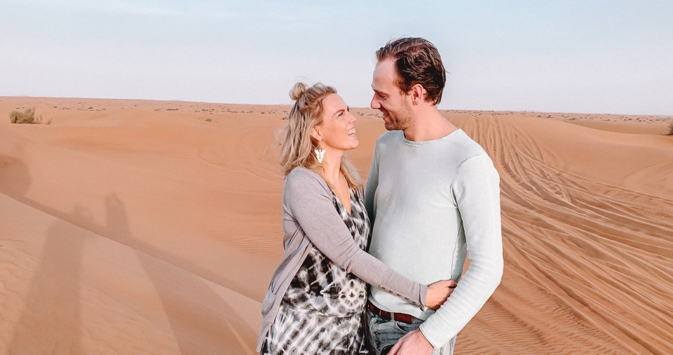 een man en vrouw staan in de woestijn