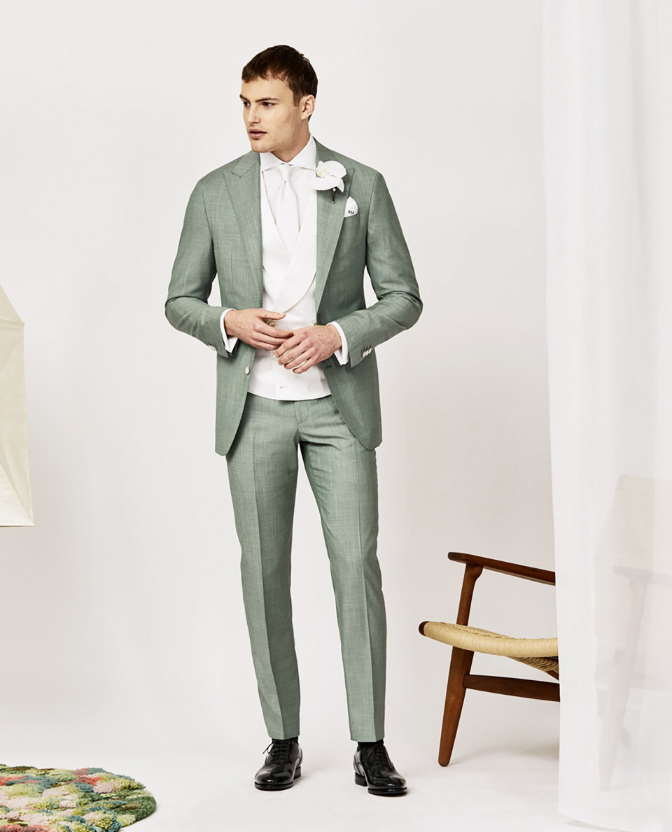 een man in een groen pak en wit overhemd