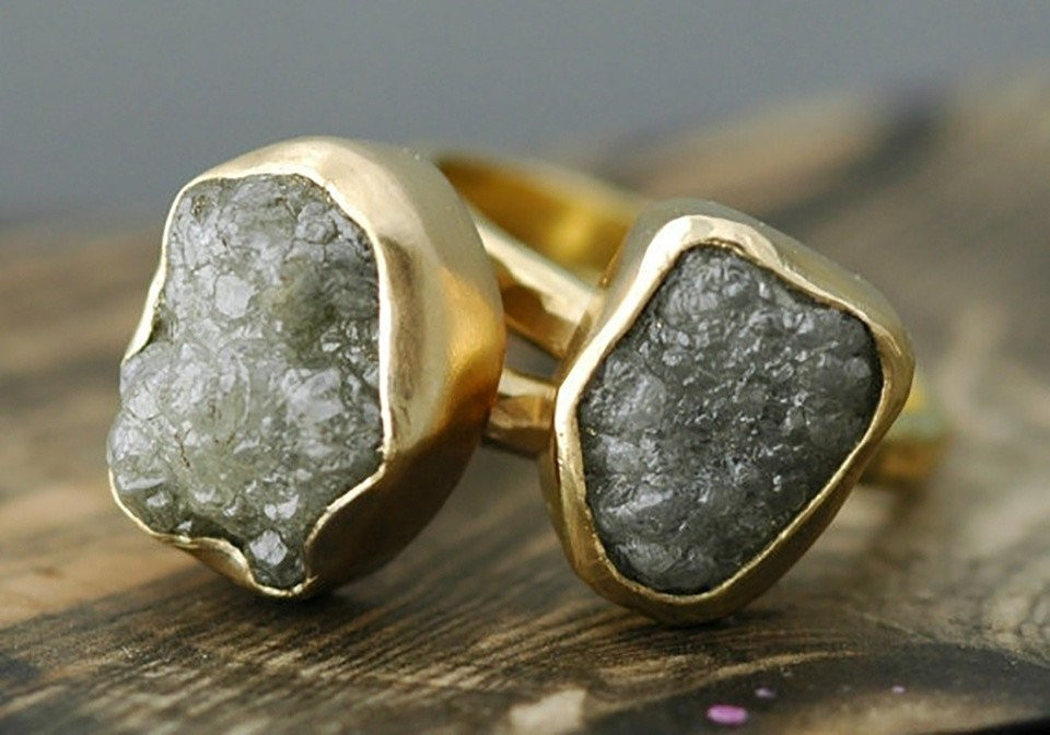 twee gouden ringen met een grijze steen erop