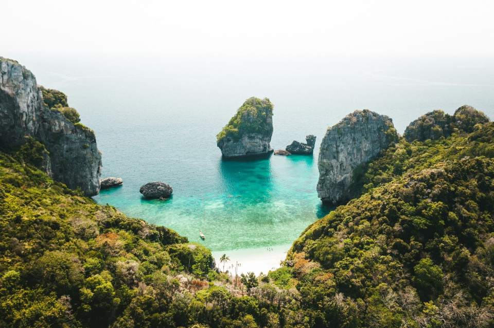het prachtige strand en de rotsachtige kliffen in de oceaan in Thailand