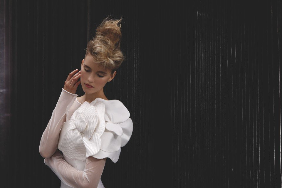 een vrouw in een witte jurk poseren voor een foto
