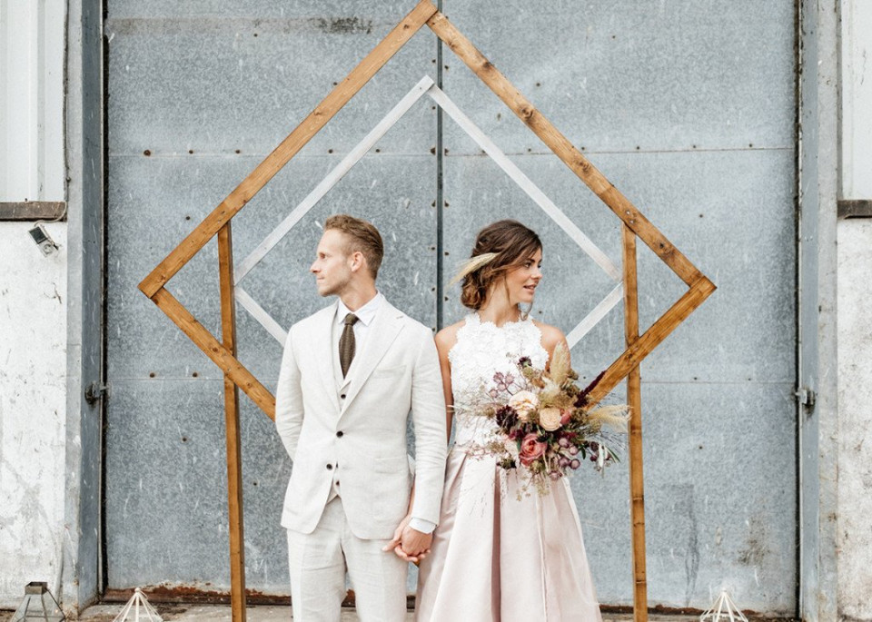 een bruid en bruidegom poseren voor een foto voor een geometrisch frame