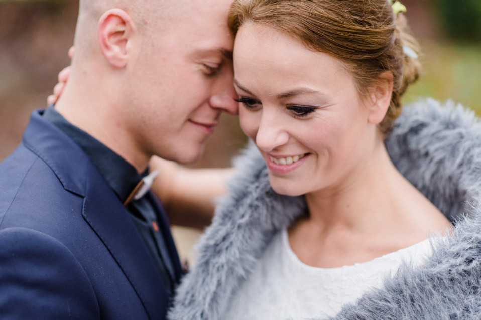 een bruid en bruidegom omarmen elkaar in een park