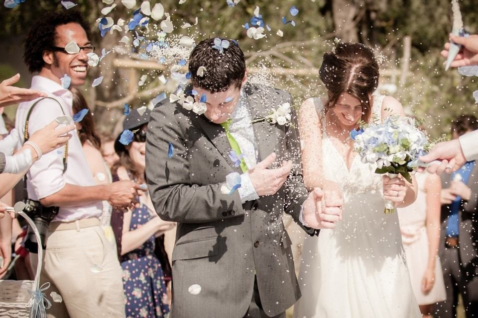 een bruid en bruidegom worden omringd door confetti
