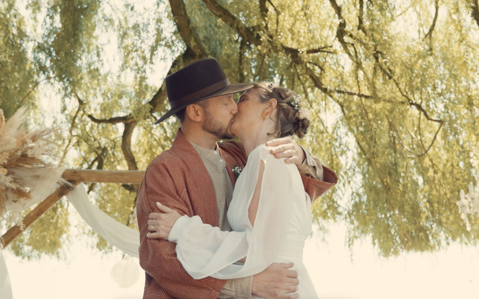 een man en een vrouw die onder een boom kussen