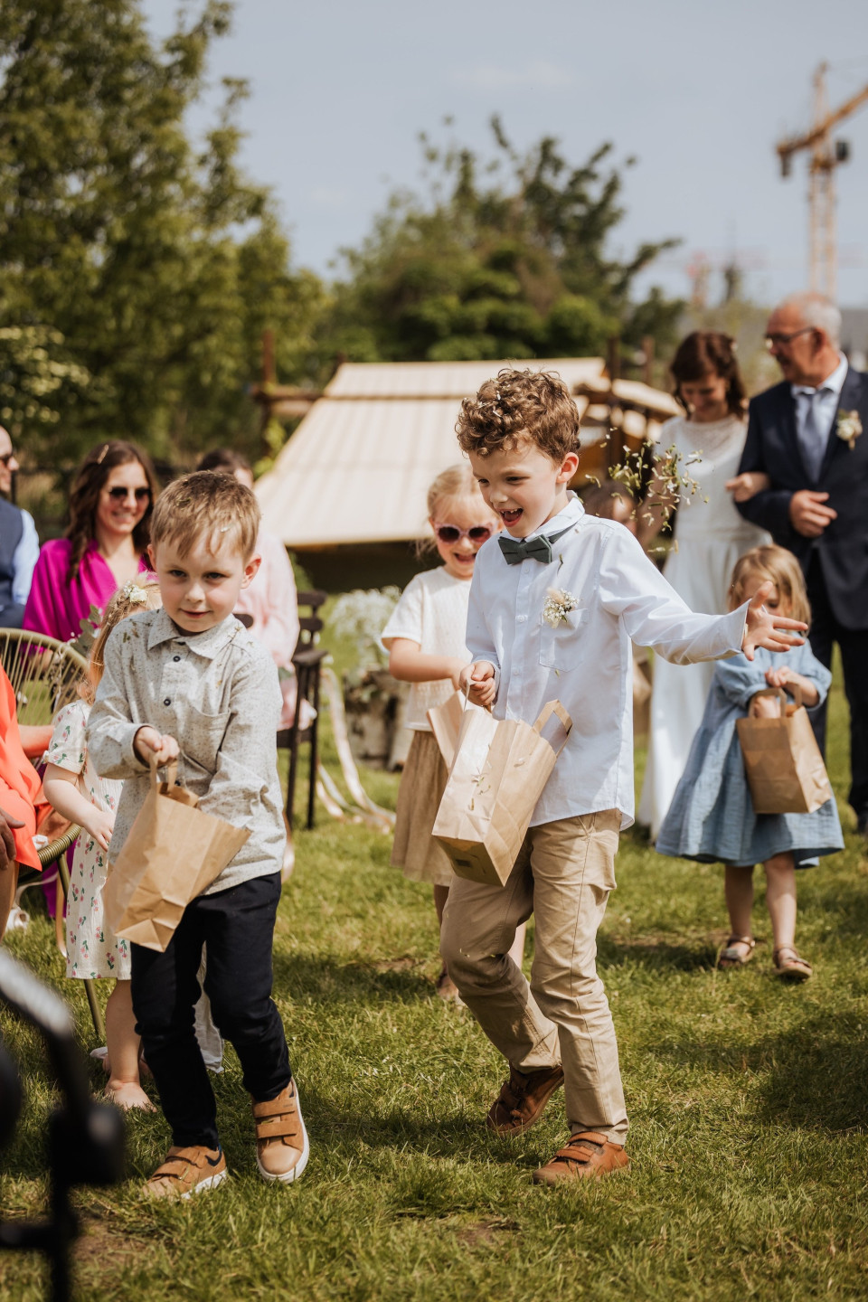 een paar kinderen die het pad aflopen met papieren zakken in hun handen en een man in een pak op de achtergrond
