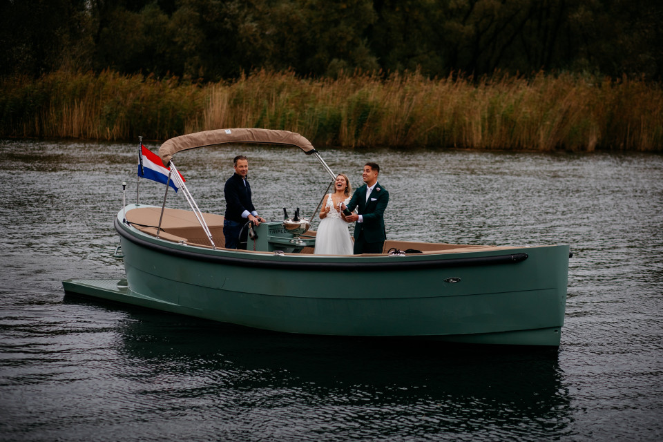 een bruid en bruidegom op een boot in het water