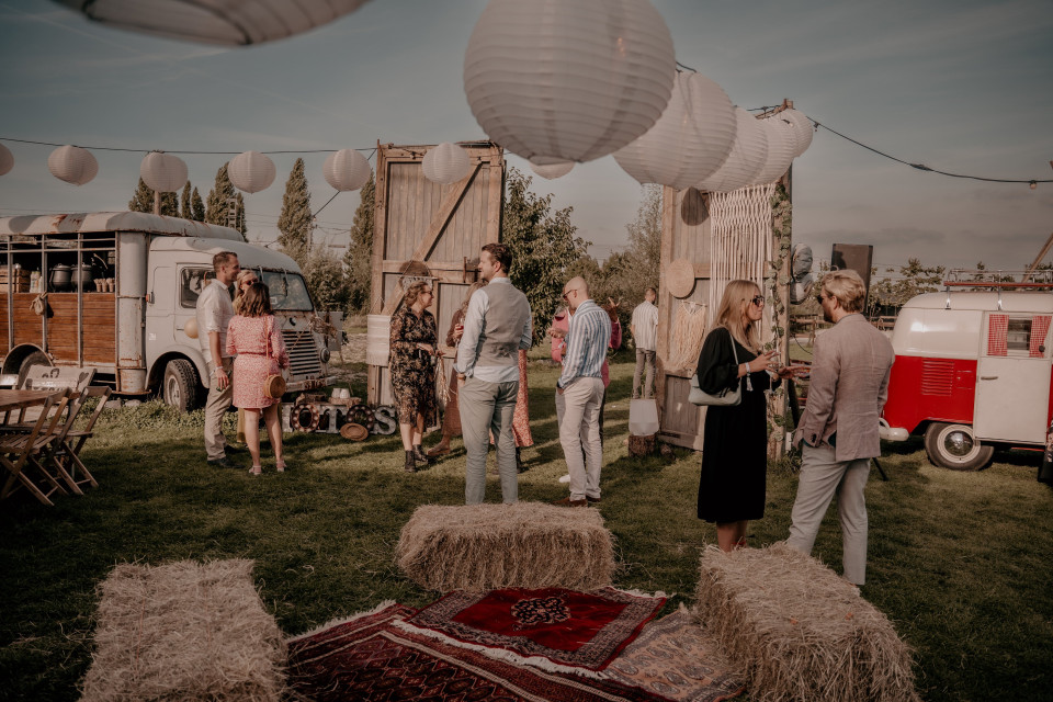 mensen staan rond een hooibaal in het gras