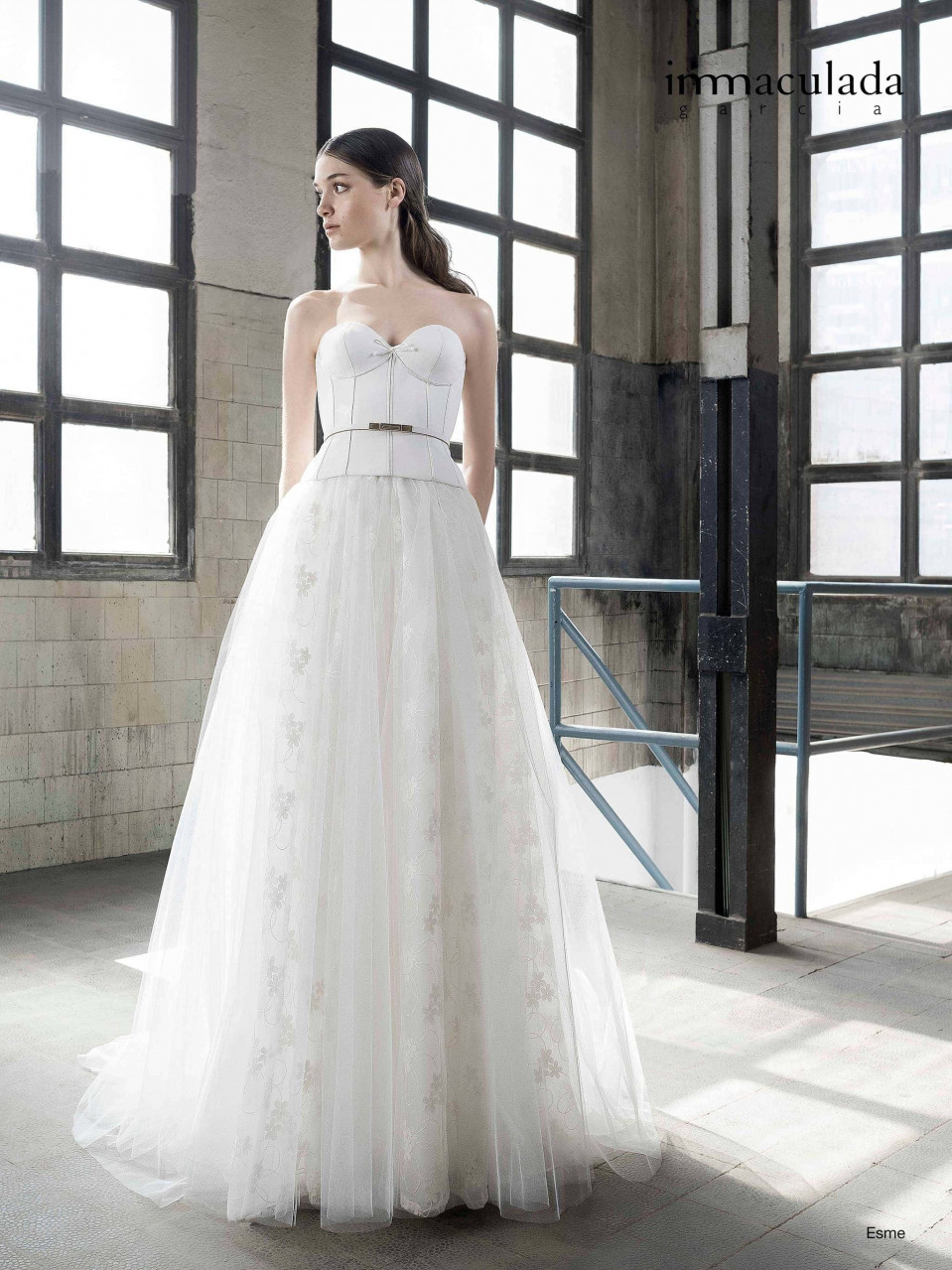 een vrouw in een trouwjurk die in een lege kamer staat