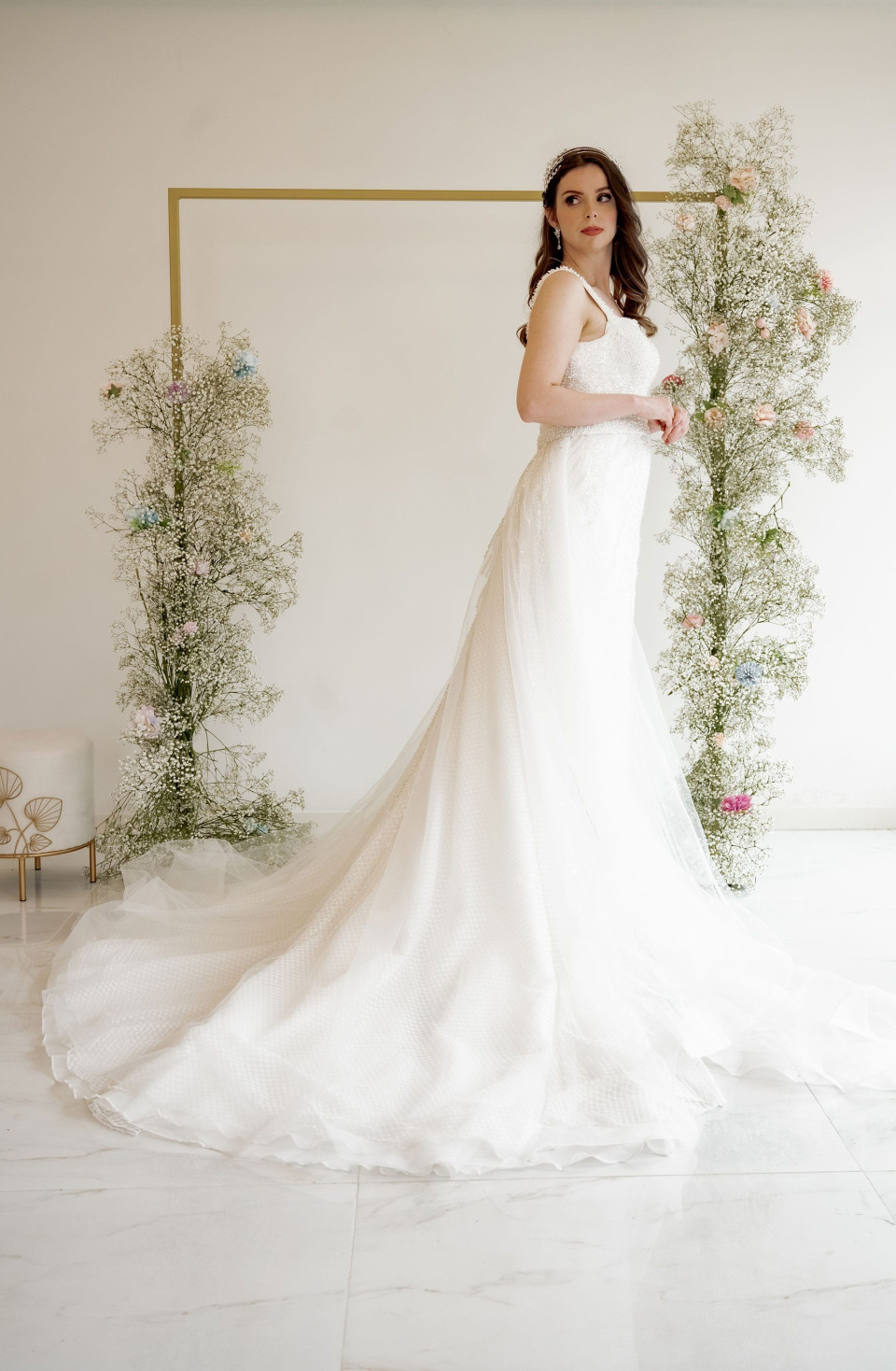 Deze elegante trouwjurk heeft een zeemeermin silhouet dat elegant het lichaam volgt voordat het uitloopt bij de knie, waardoor een prachtige zandloper vorm ontstaat. De jurk is versierd met ingewikkeld kralenwerk en pailletten, die een luxueuze glans toevoegen die perfect is voor een formele of glamoureuze locatie. Het ontwerp is bijzonder geschikt voor een zandloper lichaamstype, omdat het de rondingen accentueert en zorgt voor een evenwichtige verhouding.