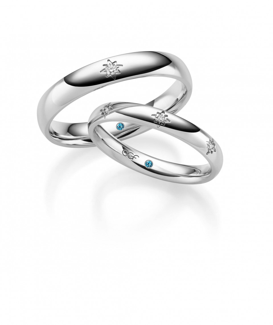 twee trouwringen met blauwe diamanten erop