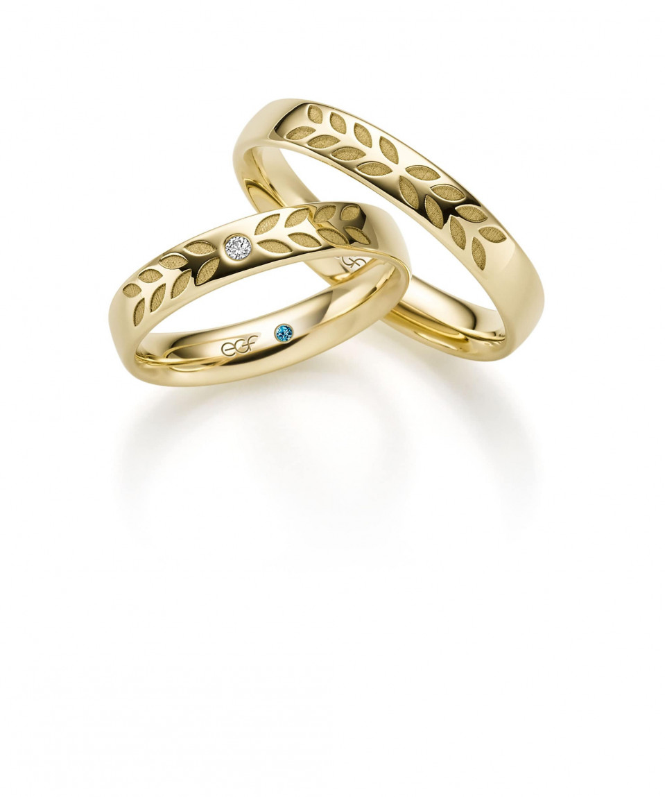 twee trouwringen met bladeren en diamanten