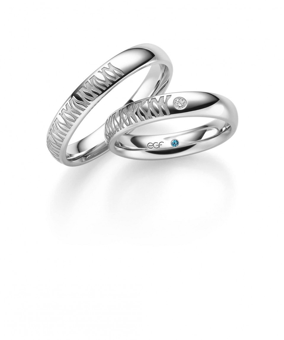 twee trouwringen met blauwe diamanten erop