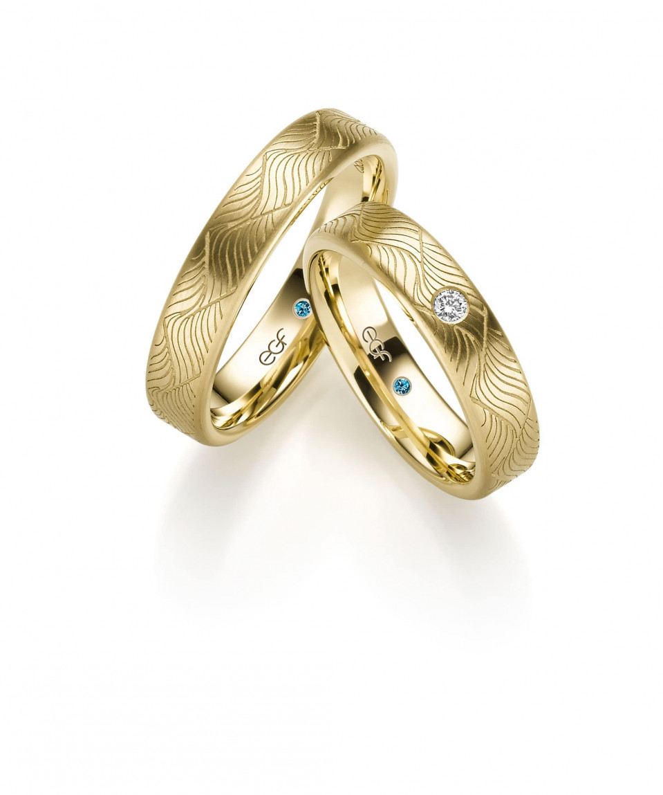 twee trouwringen met een diamant in het midden