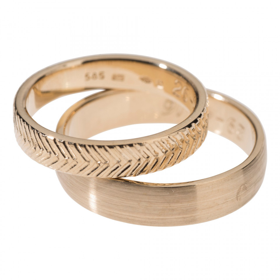 twee trouwringen met een chevron patroon erop