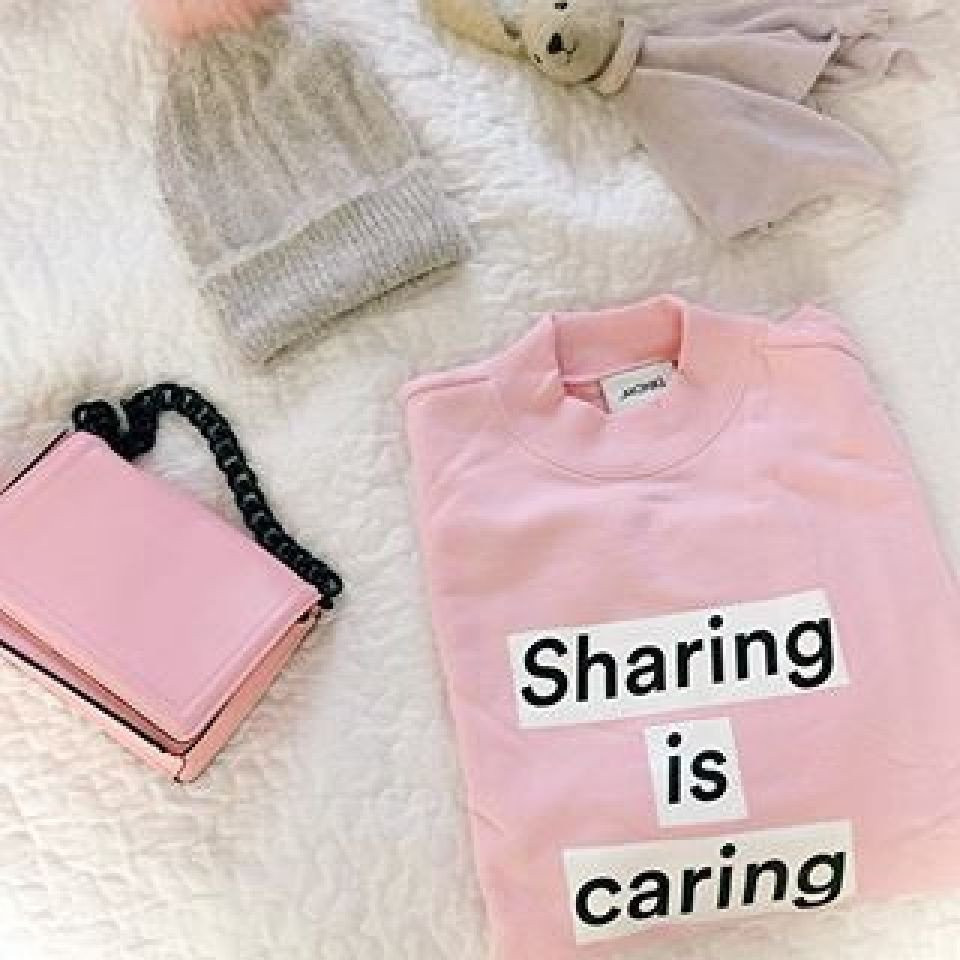een roze trui met de woorden delen is zorgen erop geschreven