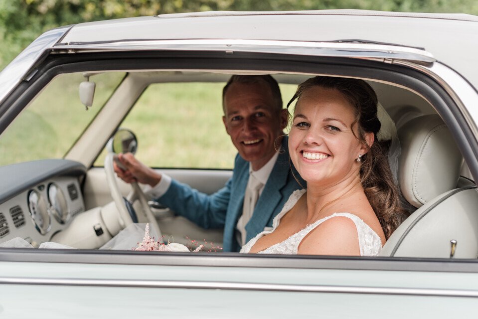 een bruid en bruidegom in een vintage auto
