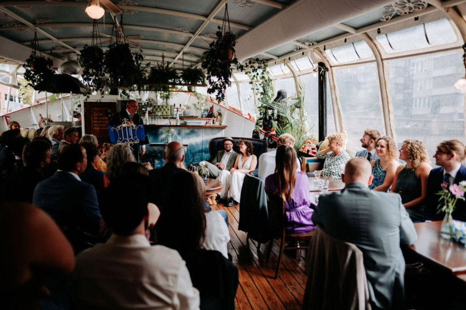 een bruiloftsfeest op een boot met een groot raam