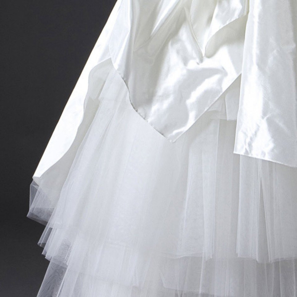 een close-up van een trouwjurk met een witte rok