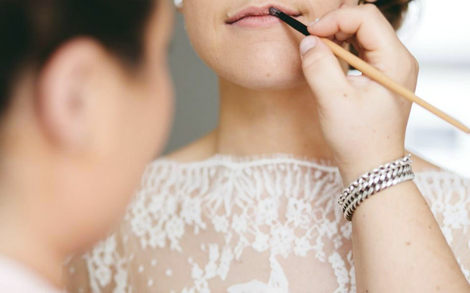 een vrouw krijgt haar make-up gedaan door een andere vrouw