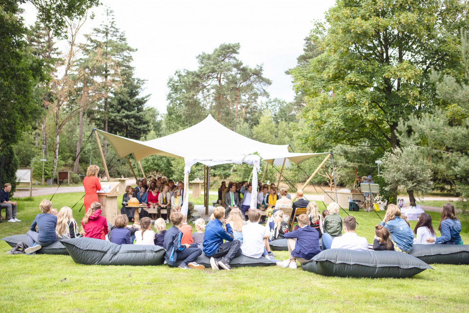 een groep mensen zittend op zitzakken in het gras