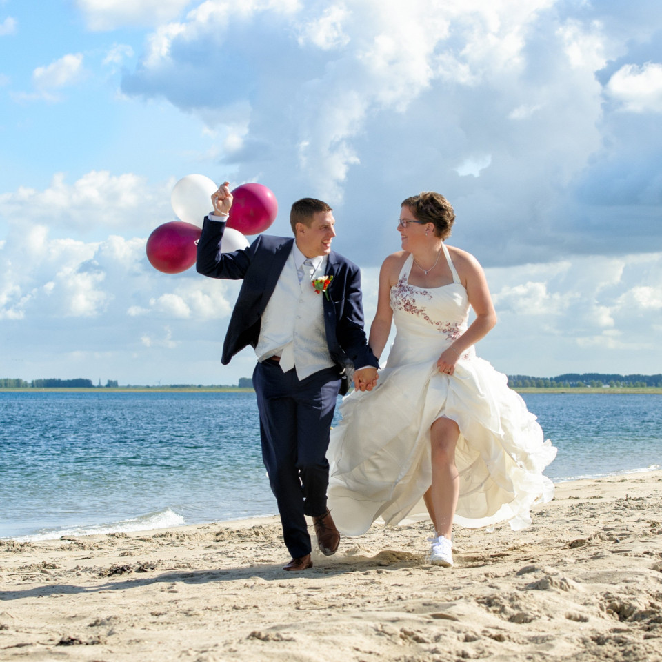 een man en een vrouw lopen op het strand