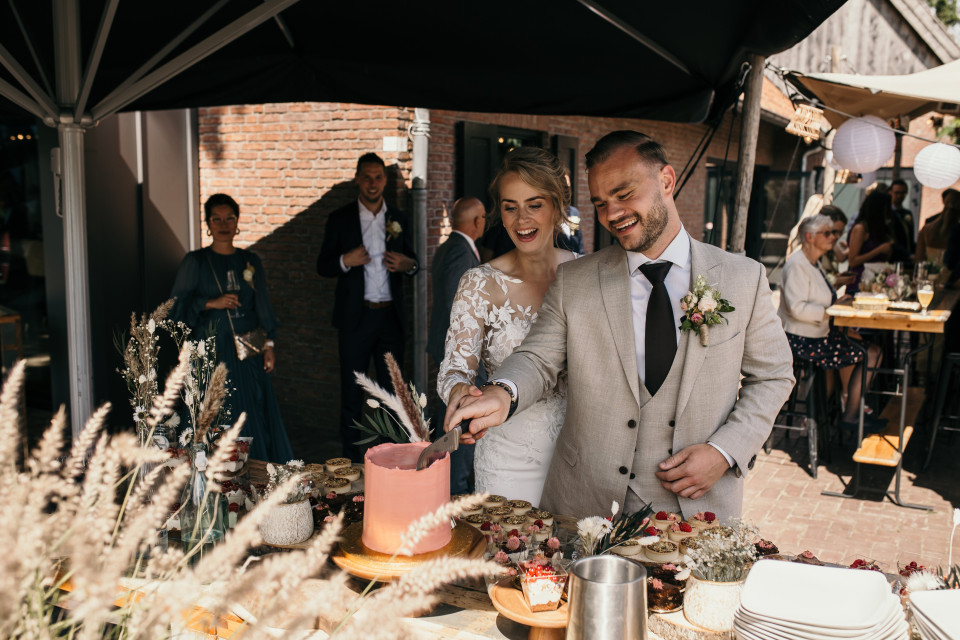 het pasgetrouwde stel dat hun bruidstaart snijdt