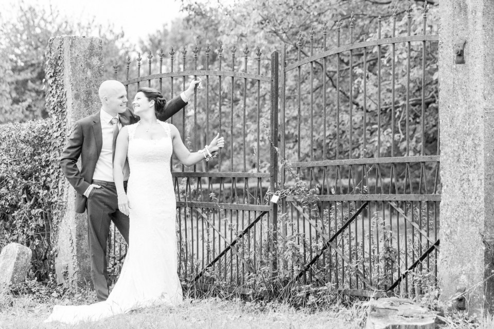een bruid en bruidegom staan voor een ijzeren hek