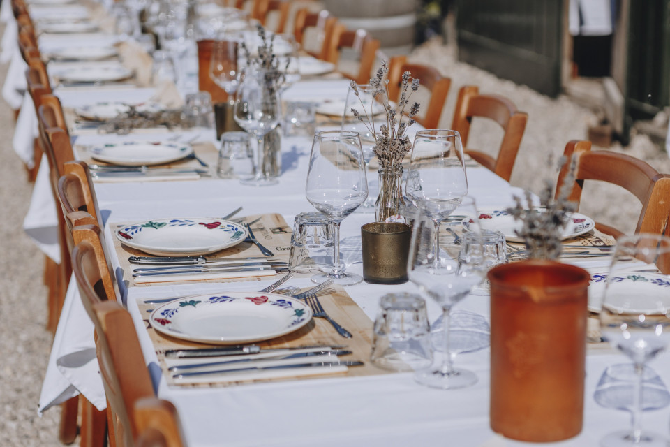 een lange tafel met witte borden en tafelinstellingen