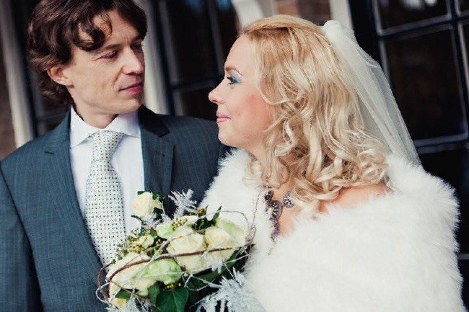 een man en vrouw in trouwkleding staan naast elkaar