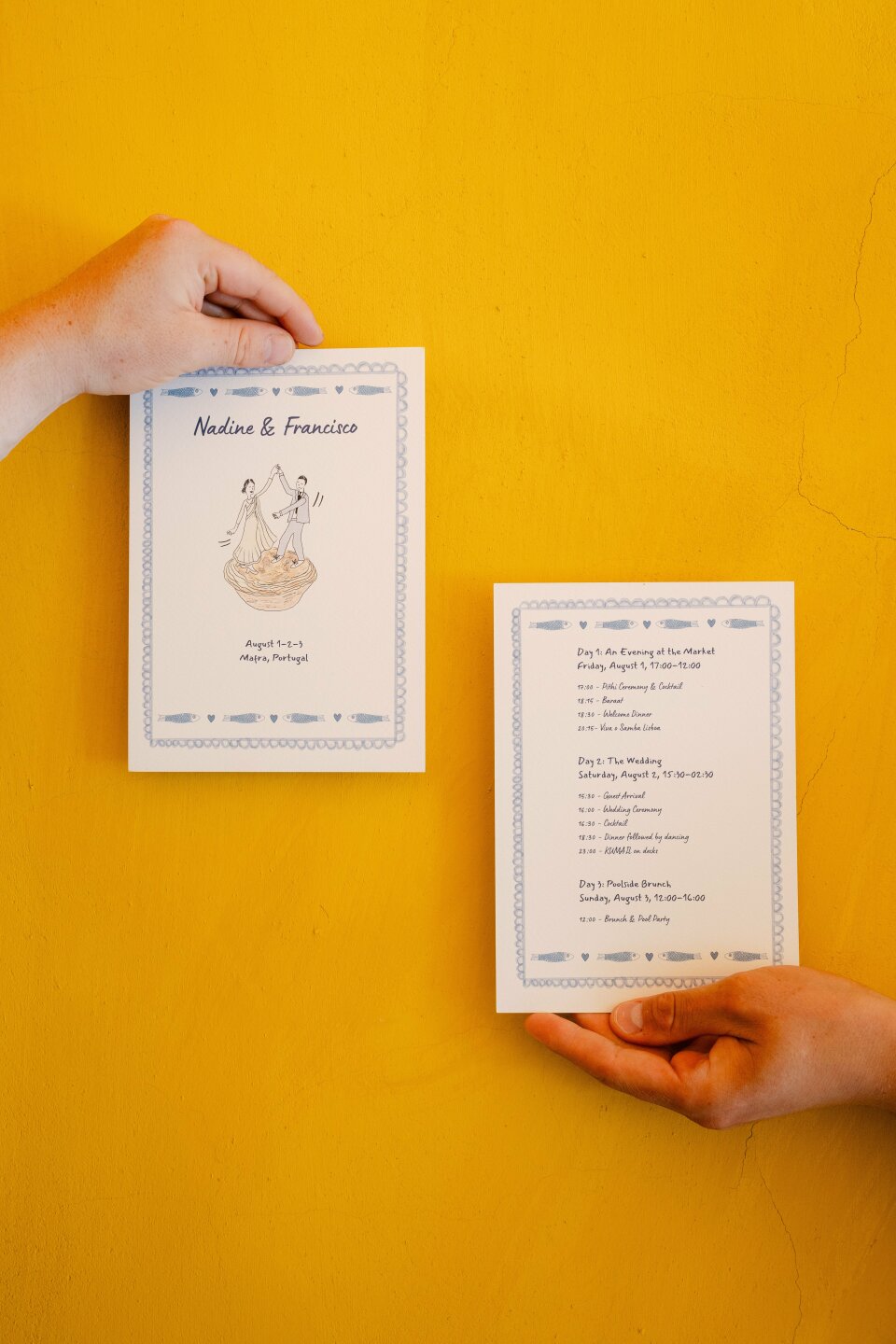 een persoon die een trouwprogramma vasthoudt op een gele muur