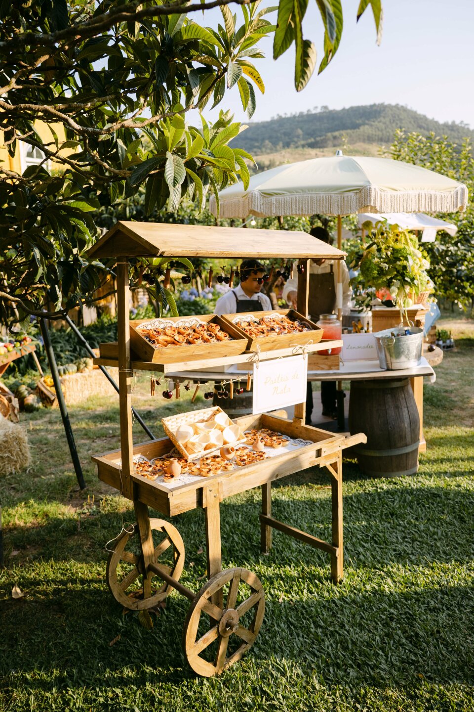 een houten kar met gebakjes erin in het gras