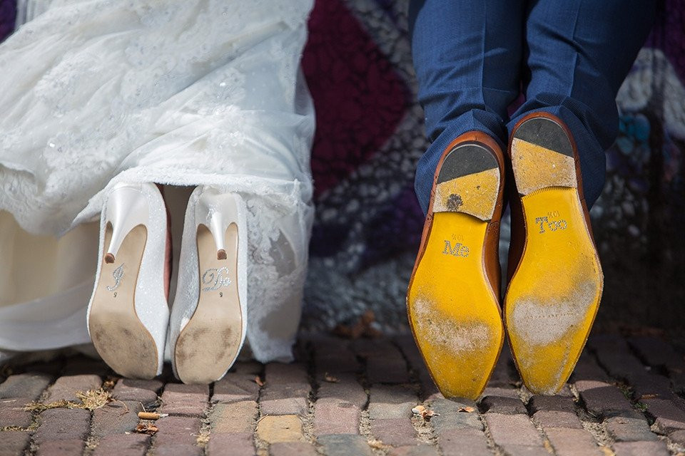 bruid en bruidegom's schoenen voor een graffiti muur