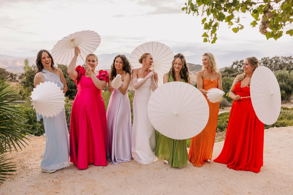 een groep vrouwen die paraplu's vasthouden en poseren voor een foto