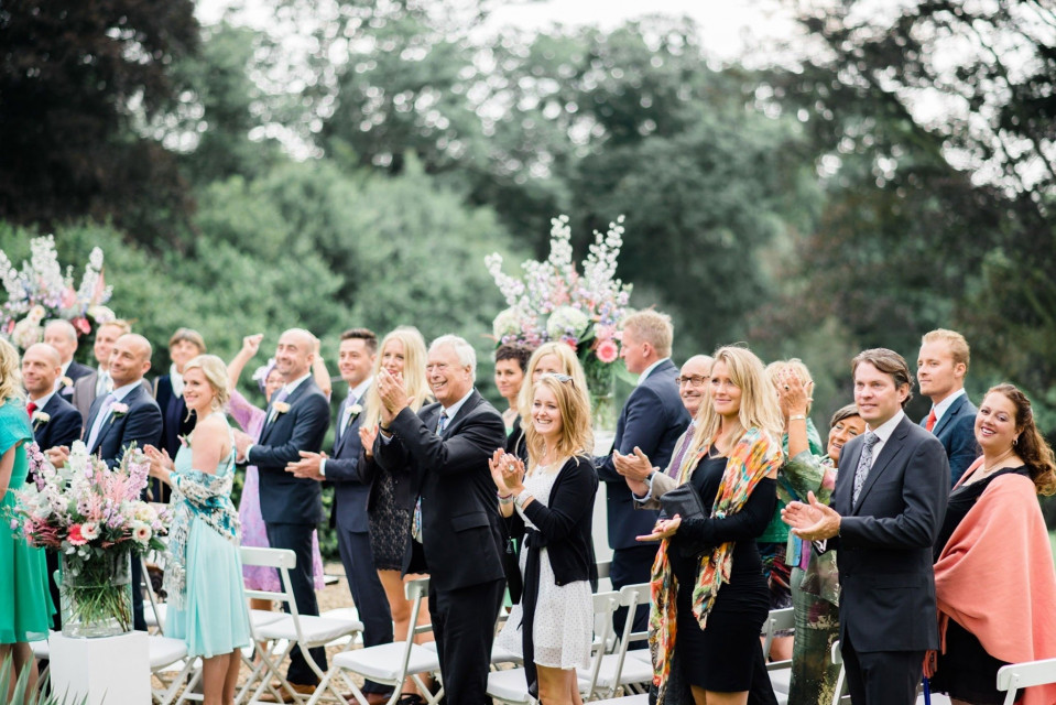 een trouwceremonie in het park met applaudisserende mensen
