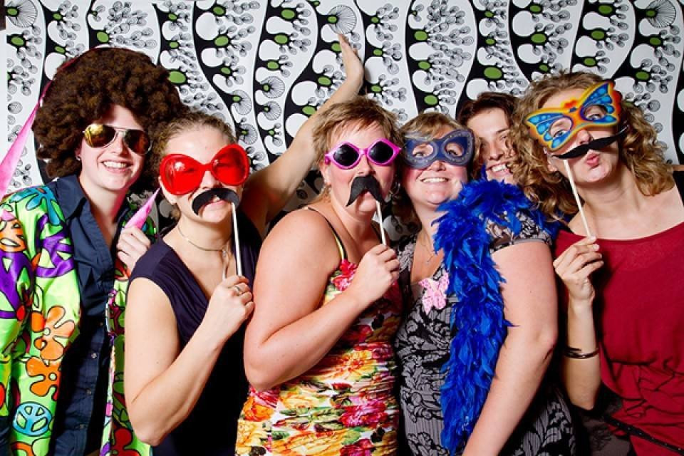 een groep mensen poseren voor een foto met nep-snorren