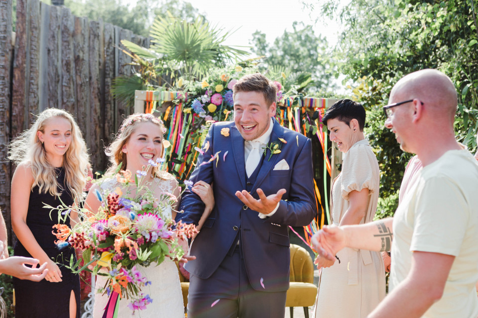een bruid en bruidegom worden omringd door confetti
