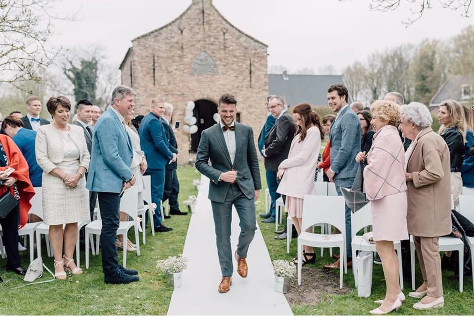 een man die door het gangpad loopt op een bruiloft