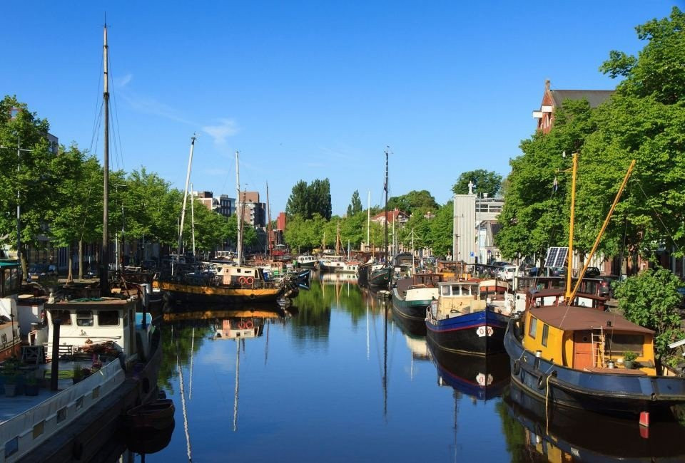 een gracht met boten en bomen op de achtergrond