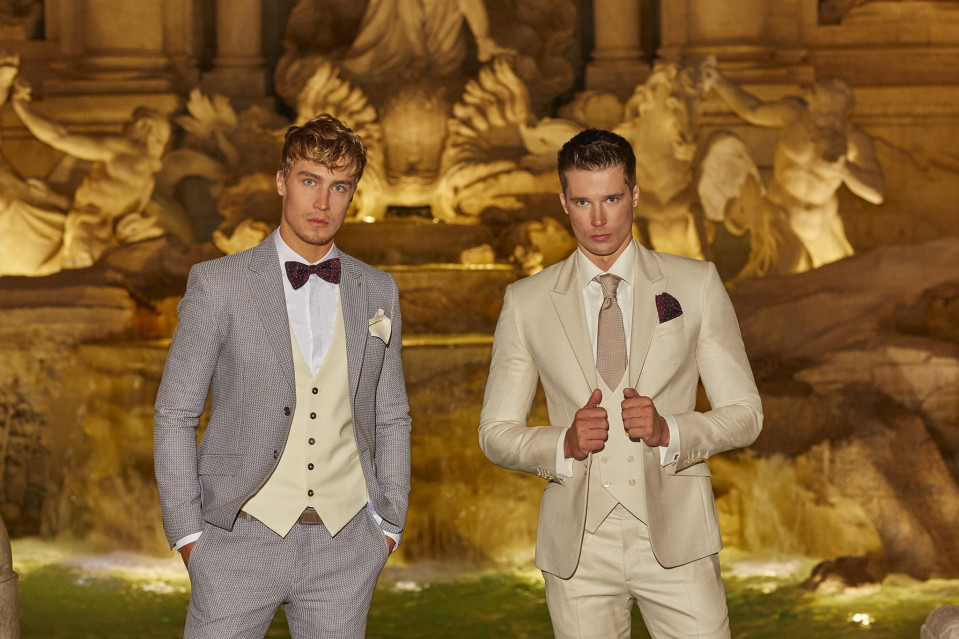 twee mannen in pakken staan naast een fontein