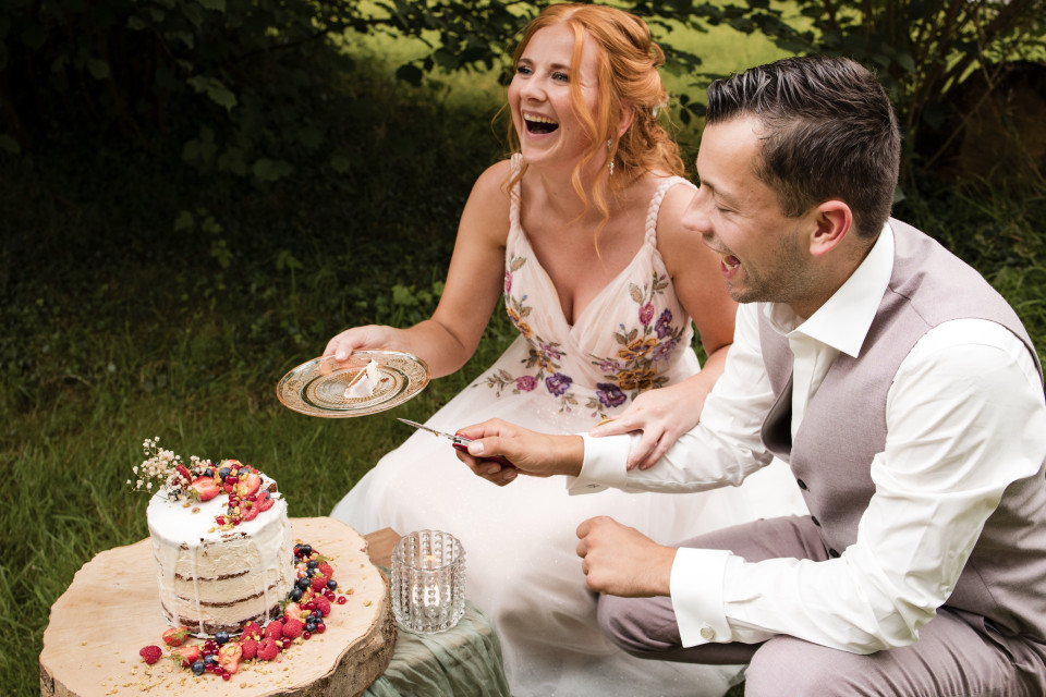 een man en vrouw zitten op een bank met een taart