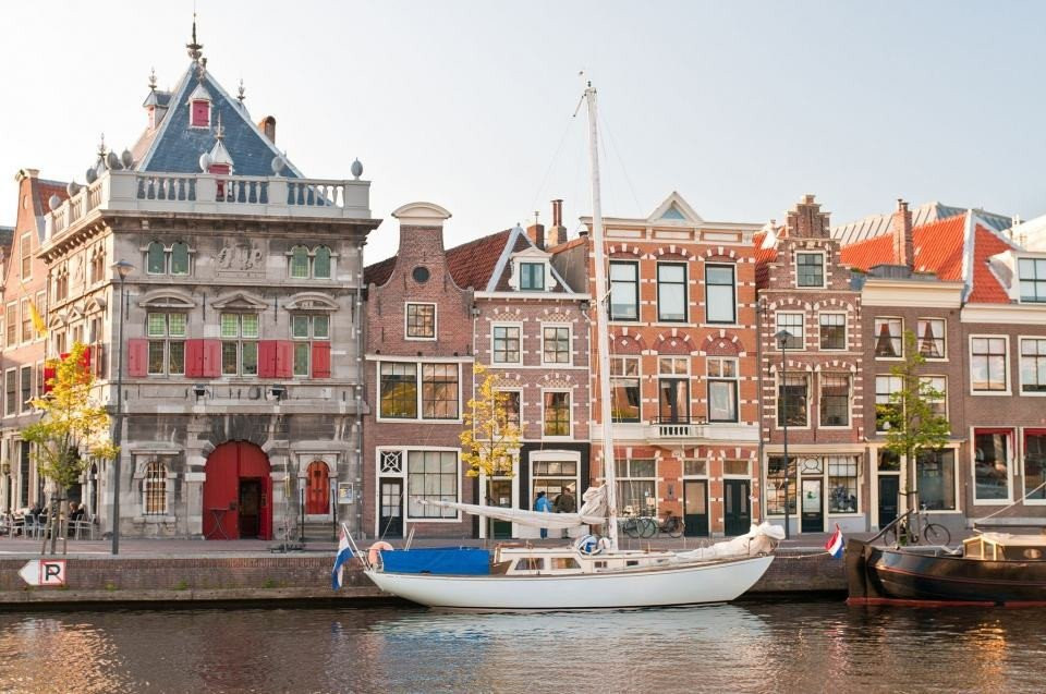 een gracht met boten en gebouwen op de achtergrond