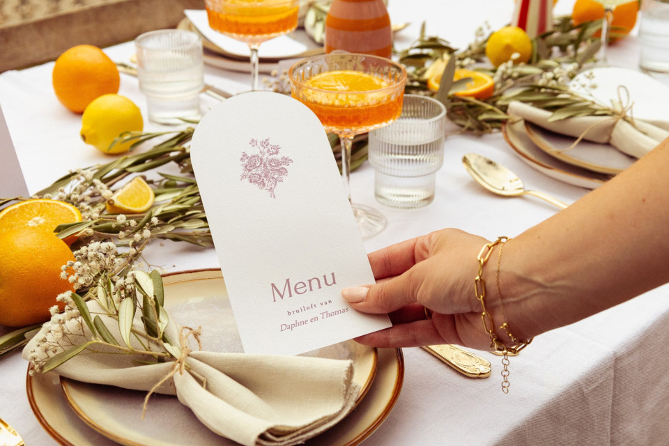 een persoon die een menukaart op een tafel vasthoudt