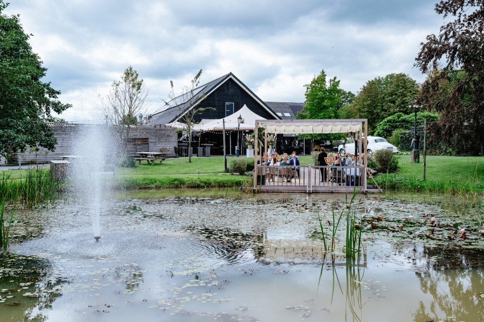 een vijver met een fontein voor een huis