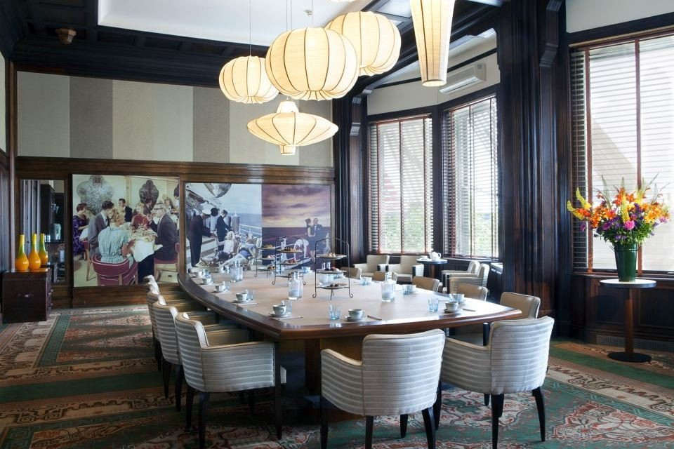 een grote eetkamer met een lange tafel en stoelen