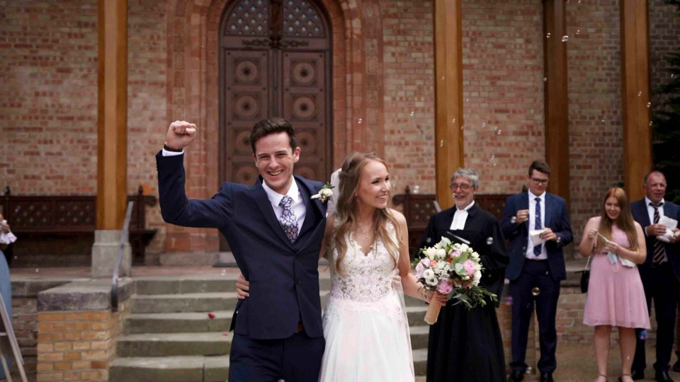 een bruid en bruidegom lopen de kerk uit na hun huwelijk