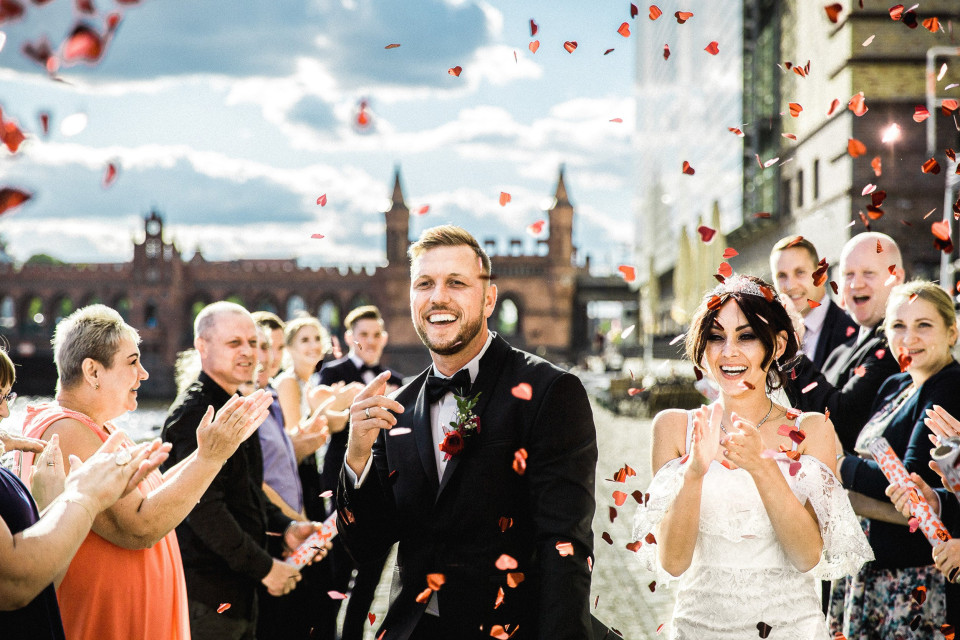 een bruiloftsgroep met confetti die op hen valt