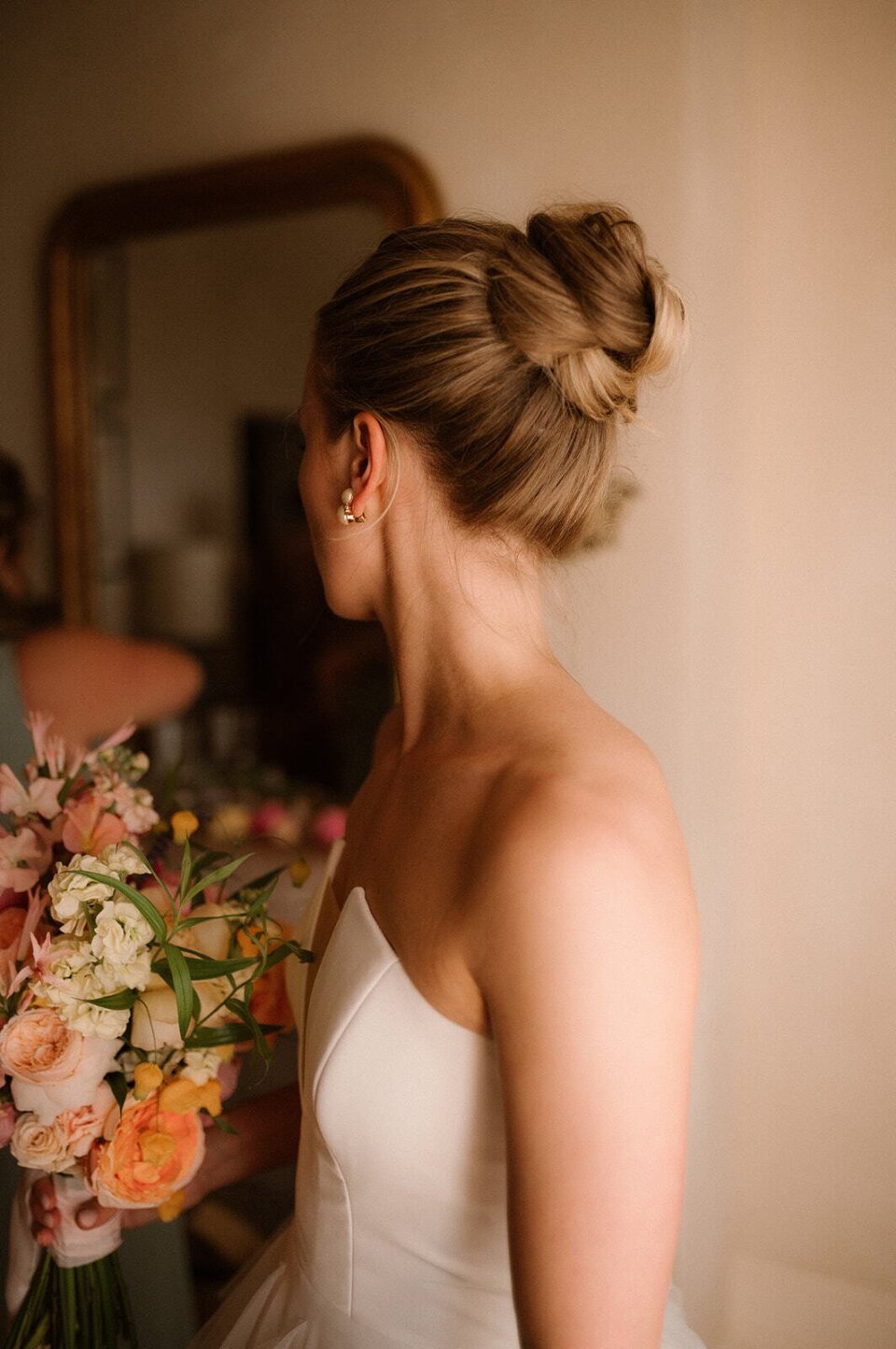 een vrouw in een trouwjurk die een boeket bloemen vasthoudt